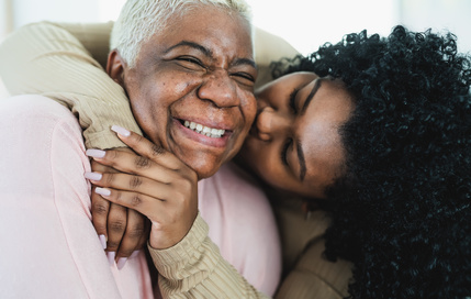Smiling woman embracing elderly mother